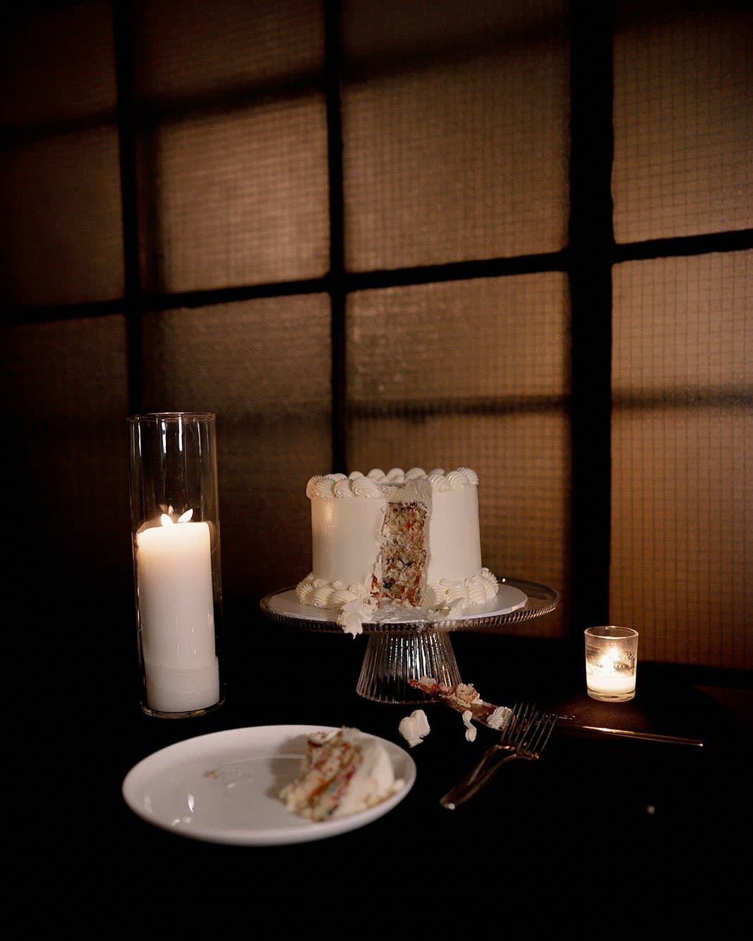 Wedding cake with confetti layers and candlelight